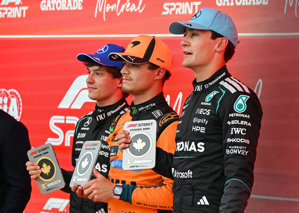 First place finisher Mercedes driver George Russell, right, of Britain, poses with from left, Mercedes driver Kimi Antonelli, of Italy, who placed third, and McLaren driver Lando Norris, of Britain, who finished in second place, following the sprint race at the F1 Canadian Grand Prix auto race in Montreal, Saturday, May 23, 2026. (Graham Hughes/The Canadian Press via AP)
