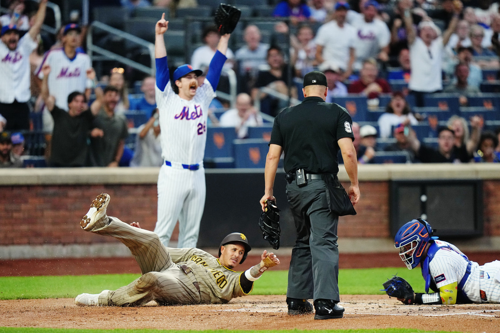 New York Mets pitcher Nolan McLean reacts after catcher Francisco Alvarez, right, tagged out San Diego Padres' Manny MacHado during the first inning of a baseball game Monday, Aug. 17, 2026, in New York. (AP Photo/Frank Franklin II)