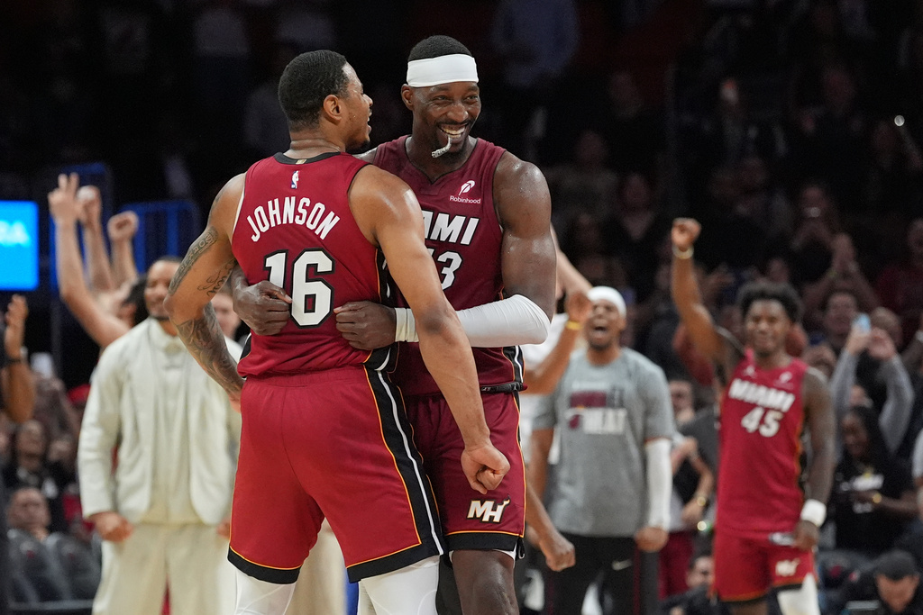 Miami Heat center Bam Adebayo (13) celebrates with forward Keshad Johnson (16) after reaching 83 points, the second-highest single game total in NBA history, in the second half of an NBA basketball game against the Washington Wizards, Tuesday, March 10, 2026, in Miami. (AP Photo/Rebecca Blackwell)