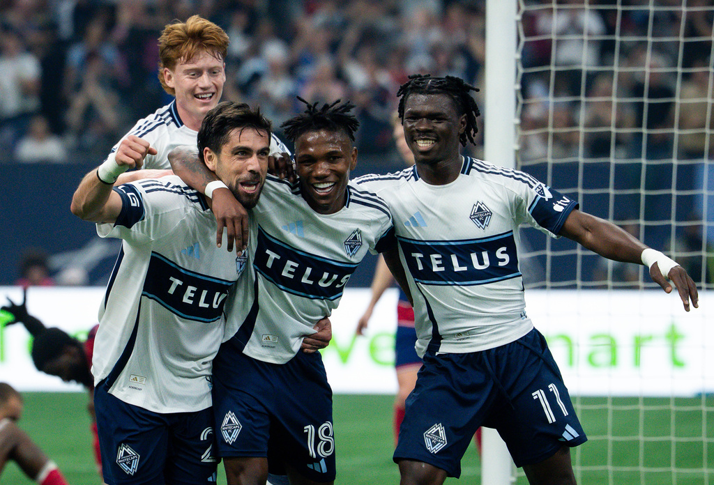 Vancouver Whitecaps' Brian White, left, celebrates his goal against FC Dallas with Edier Ocampo (18), Emmanuel Sabbi (11) and Oliver Larraz, back, during the first half of an MLS soccer match in Vancouver, British Columbia, Saturday, Aug. 22, 2026. (Ethan Cairns/The Canadian Press via AP)