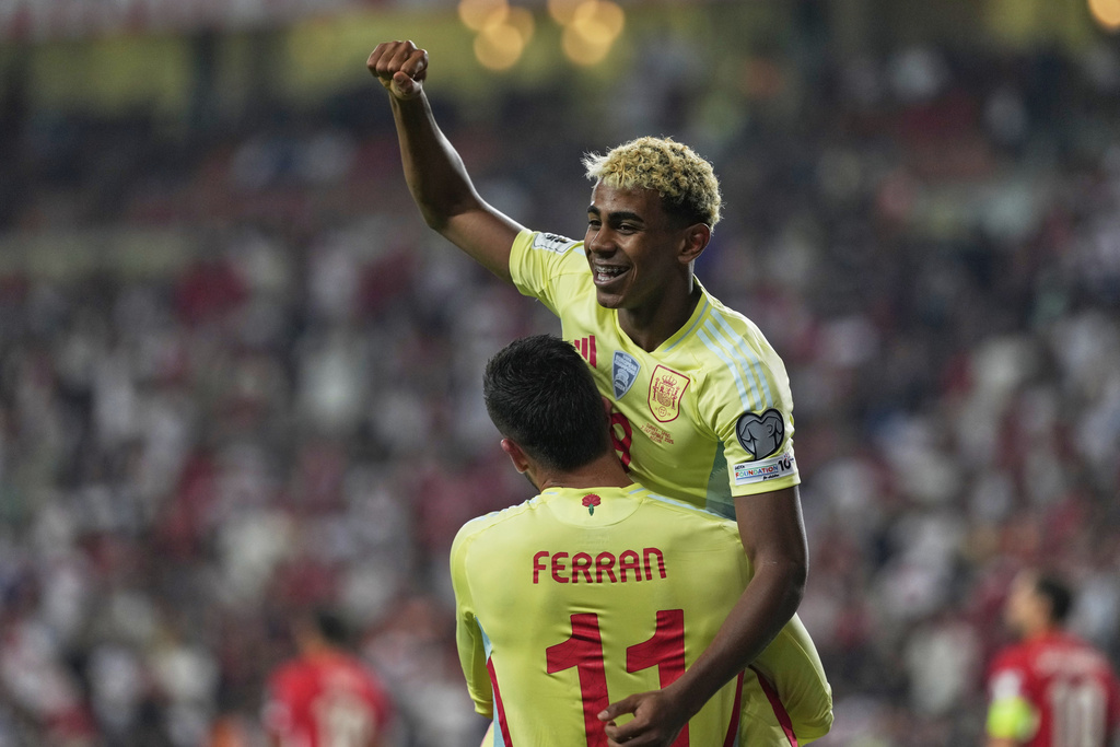 Spain's Ferran Torres, bottom, is congratulated by Lamine Yamal after scoring his side's 4th goal during a World Cup qualifying round Group E soccer match between Turkey and Spain at Konya Buyuksehir stadium, in Konya, Turkey, Sunday, Sept. 7, 2025. (AP Photo/Khalil Hamra)