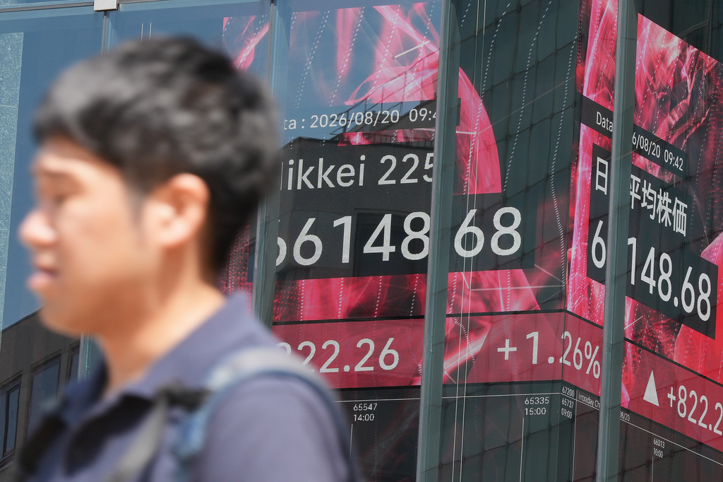 A person walks in front of an electronic stock board showing Japan's Nikkei index at a securities firm Thursday, Aug. 20, 2026, in Tokyo. (AP Photo/Eugene Hoshiko)