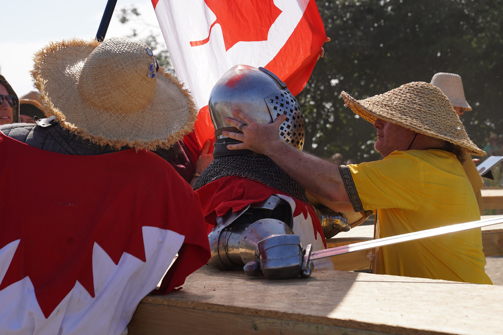 A marshal checks a fighter following a battle at the International Medieval Combat Federation's World Championship at Spottrup Castle, in Spottrup, Denmark, Thursday, July 23, 2026. (AP Photo/James Brooks)