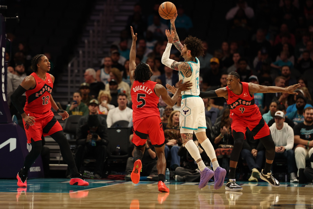 Charlotte Hornets guard Lamelo Ball (1) shoots the ball against Toronto Raptors guard Immanuel Quickley (5), Toronto Raptors forward Collin Murray-Boyles (12) , left, and Toronto Raptors forward/guard RJ Barrett (9), right, during the first half of an NBA basketball game on Wednesday, Jan. 7, 2026, in Charlotte, N.C. (AP Photo/Krista Jasso)
