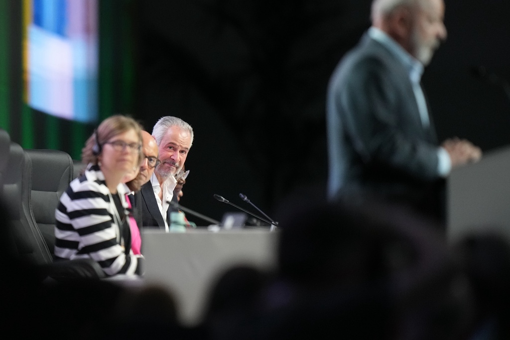 André Corrêa do Lago, COP30 president, center, listens as Brazil President Luiz Inacio Lula da Silva, right, speaks during a plenary session at the COP30 U.N. Climate Summit, Monday, Nov. 10, 2025, in Belem, Brazil. (AP Photo/Fernando Llano)