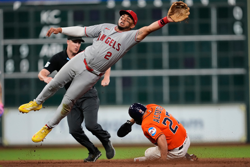 Houston Astros' Jose Altuve (27) steals second base ahead of a throw to Los Angeles Angels second baseman Oswald Peraza (2) during the fifth inning of a baseball game in Houston, Friday, March 27, 2026. (AP Photo/Ashley Landis)