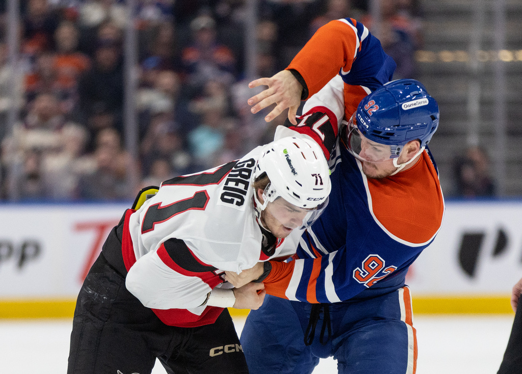 Ottawa Senators' Ridly Greig (71) and Edmonton Oilers' Vasily Podkolzin (92) fight during the first period of an NHL hockey game in Edmonton on Tuesday, March 3, 2026. (Jason Franson/The Canadian Press via AP)