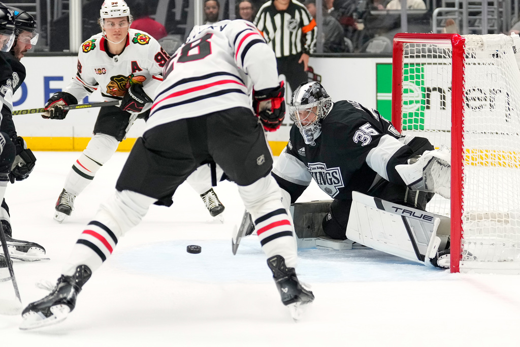 Chicago Blackhawks left wing Andre Burakovsky, center, tries to get a shot past Los Angeles Kings goaltender Darcy Kuemper during the first period of an NHL hockey game Thursday, Dec. 4, 2025, in Los Angeles. (AP Photo/Mark J. Terrill)
