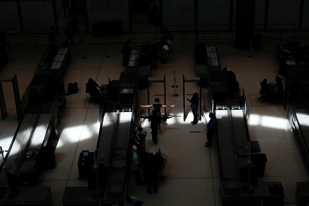 FILE - A traveler holds their arms out at a security point at Tocumen International Airport in Panama City, Dec. 4, 2025, as Copa Airlines temporarily suspends flights to and from Caracas due to pilots reporting intermittent navigation signal issues. (AP Photo/Matias Delacroix, File)