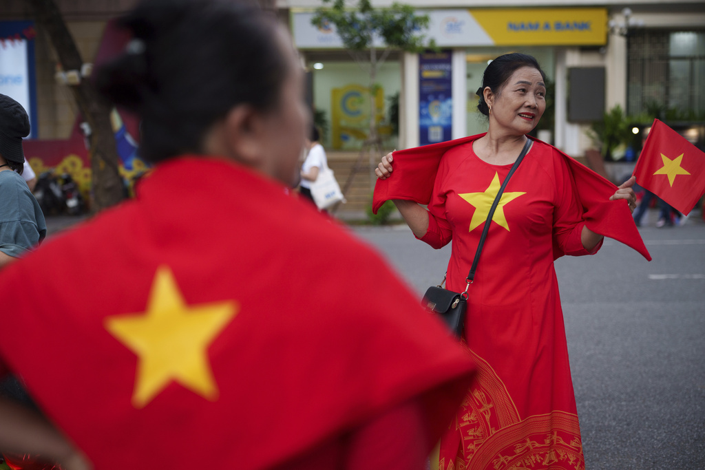 Women wear Vietnam's national flag as the nation celebrating Vietnam's 80th National Day in Hanoi, Friday, Aug. 29, 2025. (AP Photo/Vincent Thian)