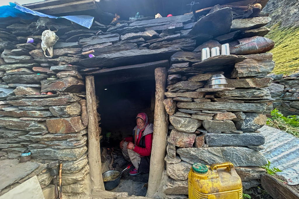 Prema Devi cooks inside her small eatery, catering to trekkers passing through on their way to the Nanda Devi Base Camp, in Ghanghar village, in the northern Indian Himalayan state of Uttarakhand, on Oct. 1, 2025. (AP Photo/Satish Sharma)