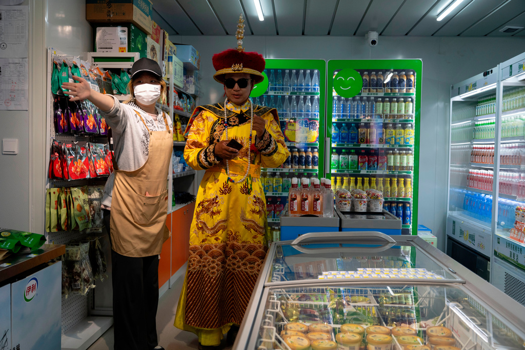 A man dressed as an emperor visits a convenience store along the popular Wangfujing shopping street in Beijing, Wednesday, May 6, 2026. (AP Photo/Ng Han Guan)