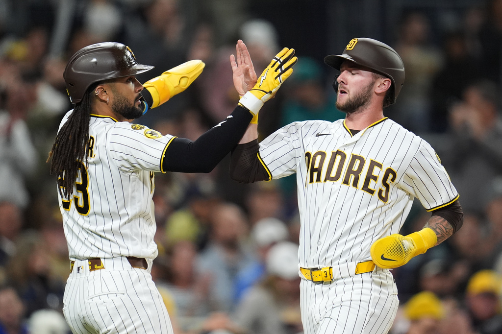 San Diego Padres' Jackson Merrill, right, and teammate Fernando Tatis Jr. celebrate after they both score off a two-RBI single by Xander Bogaerts during the third inning of a baseball game against the Seattle Mariners Tuesday, April 14, 2026, in San Diego. (AP Photo/Gregory Bull)