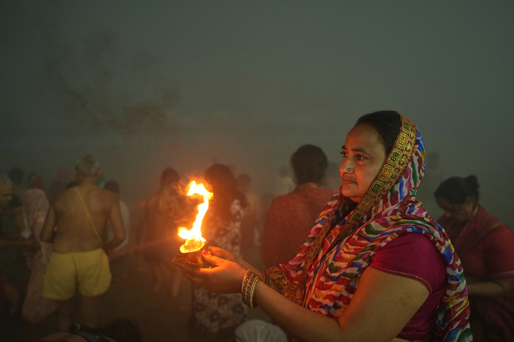 Devotees pray after holy dip on Mauni Amavasya, a divine occasion in Hindu religious practice followed for honoring ancestors or forefathers, at the Sangam, the confluence of the Ganges, the Yamuna and the mythical Saraswati rivers, during the annual month long Hindu religious fair "Magh Mela" in Prayagraj, India, Sunday, Jan. 18, 2026. (AP Photo/Rajesh Kumar Singh)