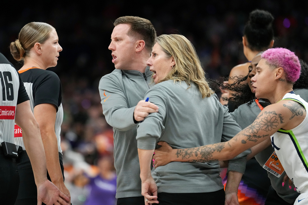 Minnesota Lynx head coach Cheryl Reeve, second from right, yells at officials as she is restrained by Lynx associate head coach Eric Thibault, center, and Lynx guard Natisha Hiedeman, right, after being ejected after earning a second technical foul during the second half of Game 3 of a WNBA basketball playoff semifinals series game against the Phoenix Mercury Friday, Sept. 26, 2025, in Phoenix. (AP Photo/Ross D. Franklin)