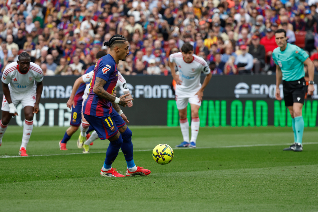 Barcelona's Raphinha scores on a penalty kick during the Spanish La Liga soccer match between Barcelona and Sevilla in Barcelona, Spain, Sunday, March 15, 2026. (AP Photo/Joan Monfort)