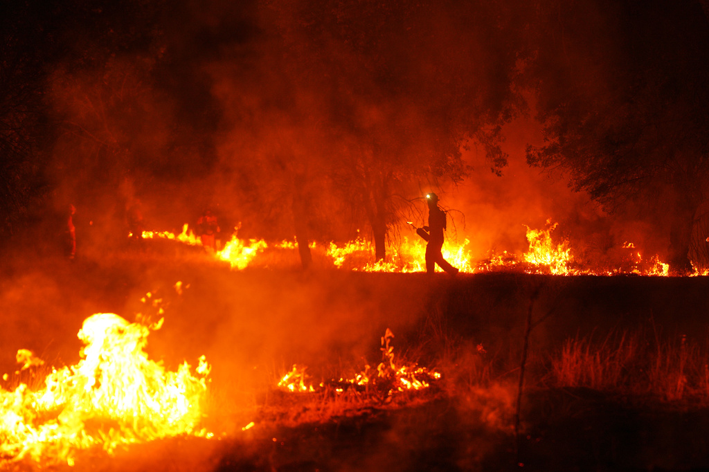 Firefighters use controlled burning to halt a wildfire that continues to spread near Cebreros, Ávila province, Spain, Tuesday, July 28, 2026. (AP Photo/Manu Fernandez)