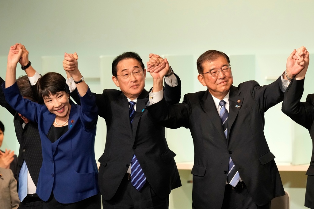 FILE - Shigeru Ishiba, right, with Sanae Takaichi, left, and Japan's Prime Minister Fumio Kishida, center, celebrates after Ishiba was elected as new the head of Japan's ruling party at the Liberal Democratic Party's leadership election, Sept. 27, 2024, in Tokyo. (AP Photo/Hiro Komae, Pool, File)