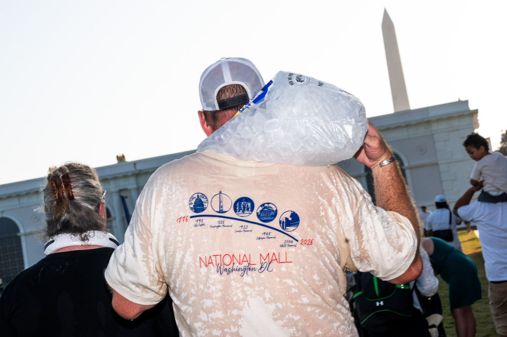 To beat the heat, Mike Monroe of Oklahoma carries a full bag of ice he bought from a vendor at the Great American State Fair on the National Mall, Thursday, July 2, 2026, in Washington. (AP Photo/Allison Robbert)