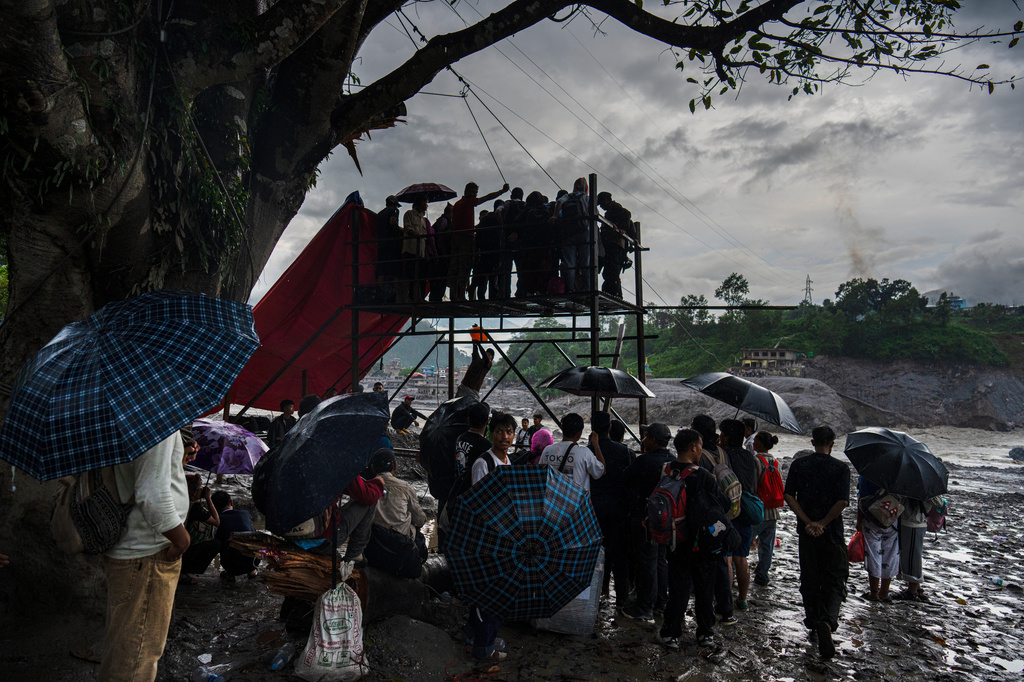 Residents wait for their turn commute across the Trishuli river on a newly installed zipline in the aftermath of flash floods at Bidur in Nepal's Nuwakot district, Nepal, Wednesday, Sept. 2, 2026. (AP Photo/Rajesh Kumar Singh)