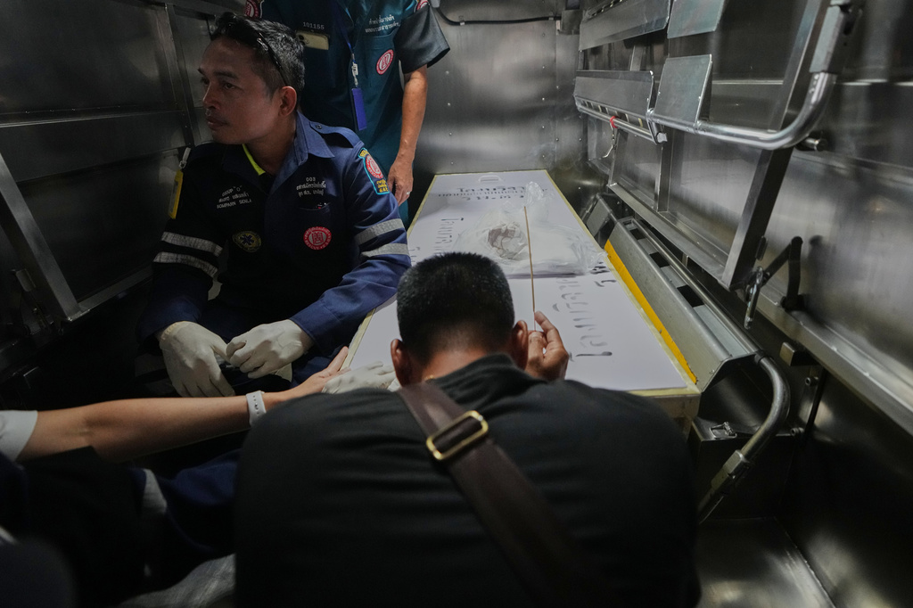 A relative of a victim in a music bar fire pays respect to the victim's body at a police hospital in Bangkok, Thailand, Tuesday, July 14, 2026. (AP Photo/Sakchai Lalit)