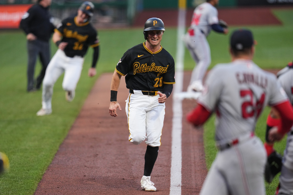 Pittsburgh Pirates' Jake Mangum (28) and Henry Davis, left rear, score on a single by Brandon Lowe off Washington Nationals pitcher Cade Cavalli (24) during the second inning of a baseball game in Pittsburgh, Monday, April 13, 2026. (AP Photo/Gene J. Puskar)