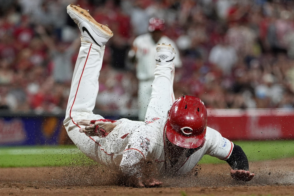 Cincinnati Reds' Sal Stewart dives across home plate to score the go-ahead run on a wild pitch by Athletics pitcher Hogan Harris during the eight inning of a baseball game in Cincinnati, Tuesday, Aug. 4, 2026. (AP Photo/Carolyn Kaster)