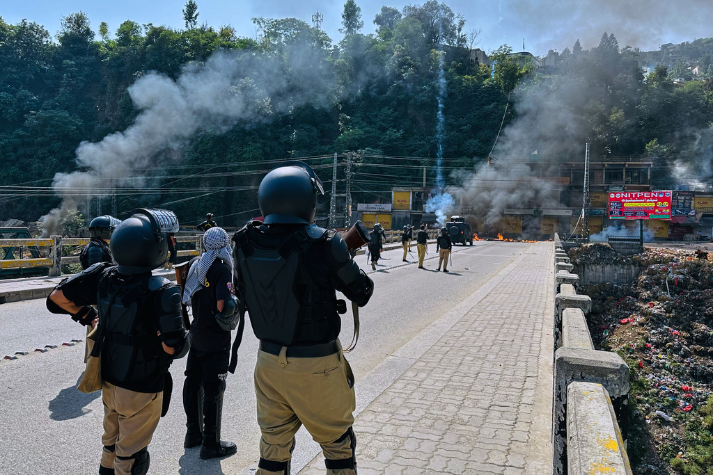 CORRECTS NAME: Police officers fire tear gas shell to disperse members of the Awami Action Committee, a civil rights alliance, holding a rally demanding subsidized food, electricity and other services in Muzaffarabad, the capital of Pakistani controlled Kashmir, Tuesday, Sept. 30, 2025. (AP Photo/M.D. Mughal)