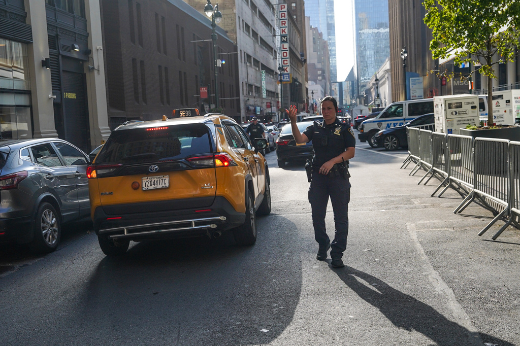 An NYPD officer waves through cars outside of Madison Square Garden ahead of a reported wedding between singer Taylor Swift and National Football League player Travis Kelce on Thursday, July 2, 2026, in New York. (AP Photo/Ryan Murphy)