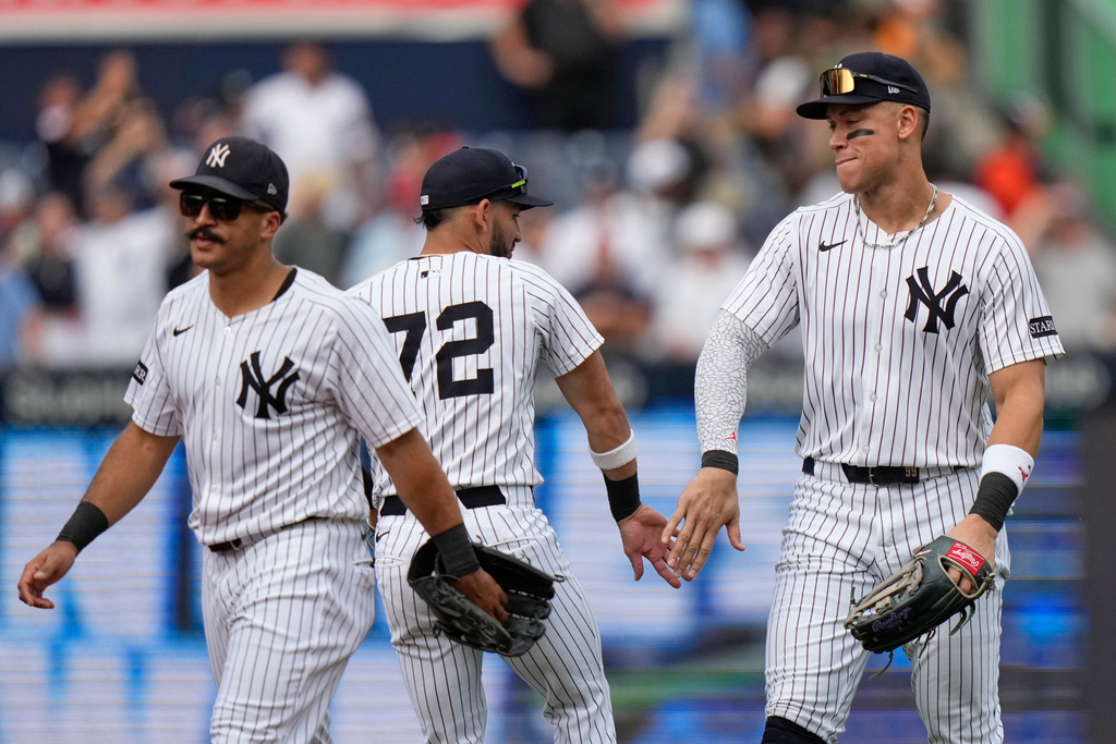 New York Yankees' Aaron Judge, right, celebrates with teammates José Caballero, center, and Trent Grisham, left, of a baseball game Saturday, Sept. 27, 2025, in New York. (AP Photo/Frank Franklin II)