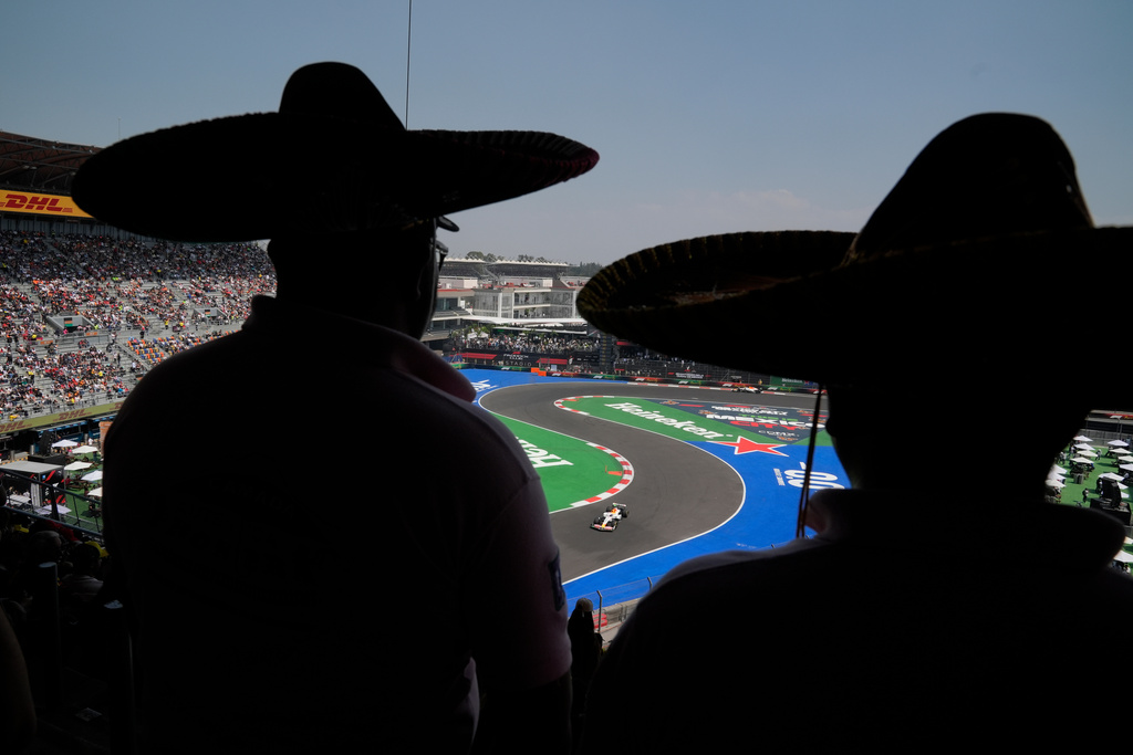 Fans wearing Mexican sombreros watch as Racing Bulls driver Isack Hadjar, of France, steers his car during a practice session ahead of the Formula One Mexico Grand Prix auto race at Hermanos Rodriguez race track in Mexico City, Friday, Oct. 24, 2025. (AP Photo/Fernando Llano)