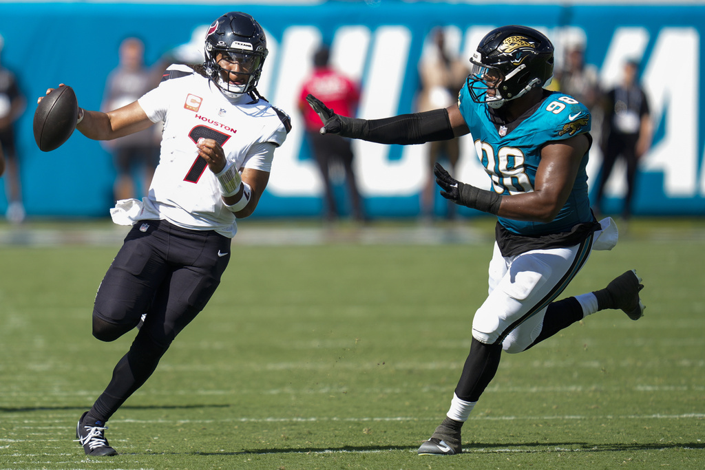 Houston Texans quarterback CJ. Stroud (7) runs the ball as Jacksonville Jaguars defensive end Dawuane Smoot (98) defends during the second half of an NFL football game Sunday, Sept. 21, 2025, in Jacksonville, Fla. (AP Photo/John Raoux)