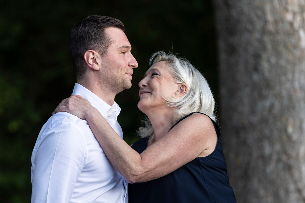 Far-right party National Rally president Jordan Bardella is embraced by far-right leader Marine Le Pen at a rally in Lievin, northern France, Saturday, July 4, 2026. (AP Photo/Jean-Francois Badias)