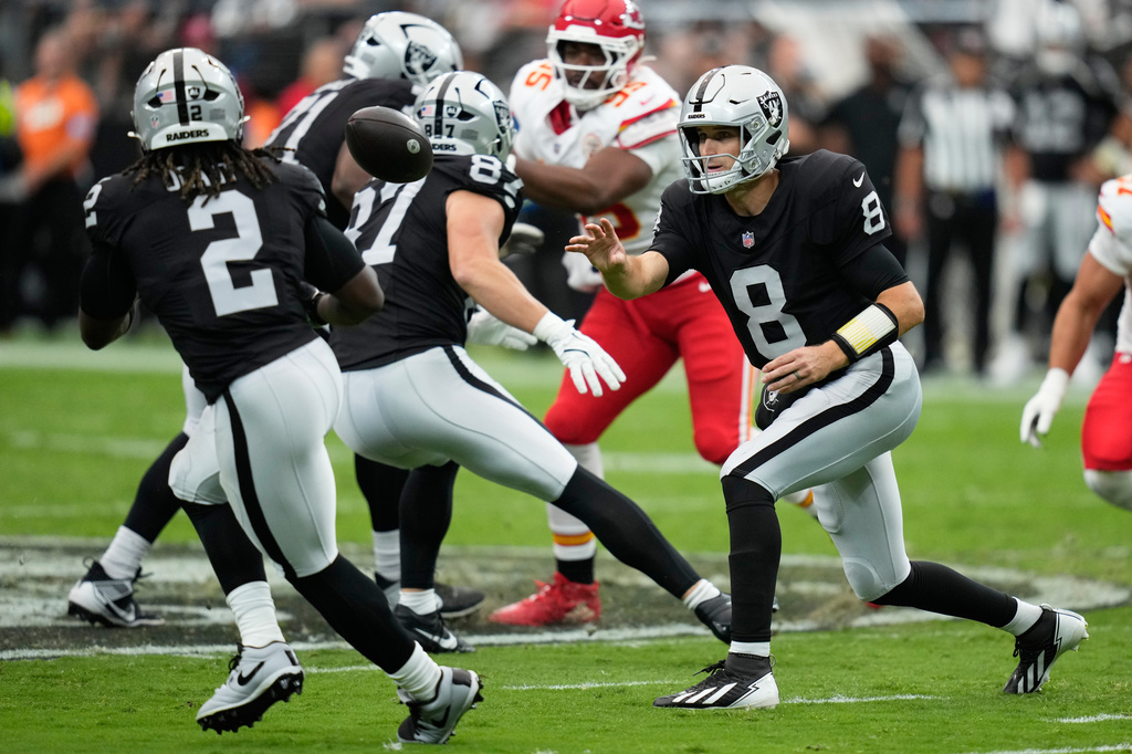 Las Vegas Raiders quarterback Kirk Cousins (8) tosses the football to running back Ashton Jeanty (2) during the first half of an NFL football game against the Kansas City Chiefs in Las Vegas, Sunday, Oct. 4, 2026. (AP Photo/John Locher)
