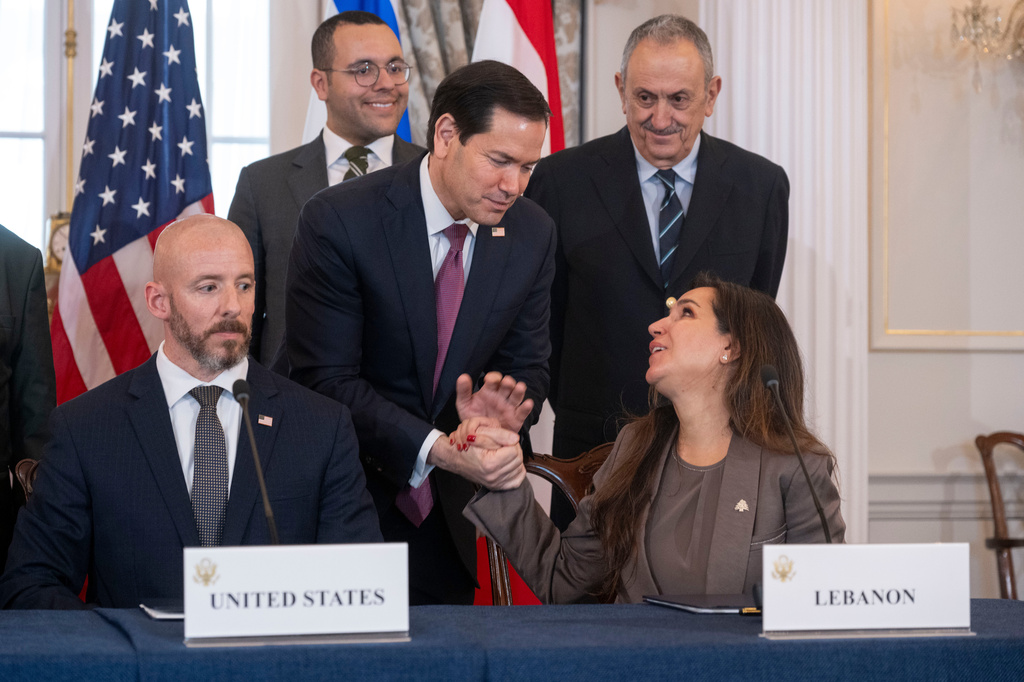 Secretary of State Marco Rubio shakes hands with Lebanon's Ambassador to the U.S. Nada Hamadeh, left, following a signing of a framework agreement, described as a first step toward peace following months of conflict between Israel and the Lebanese militant group Hezbollah, at the State Department, Friday, June 26, 2026, in Washington. At left, is Counselor Dan Holler. (AP Photo/Kevin Wolf)