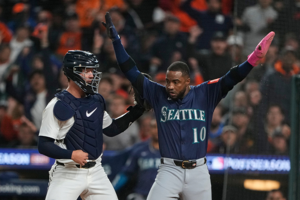 Seattle Mariners' Victor Robles (10) celebrates after scoring past Detroit Tigers catcher Dillon Dingler, left, during the third inning in Game 3 of baseball's American League Division Series Tuesday, Oct. 7, 2025, in Detroit. (AP Photo/Ryan Sun)