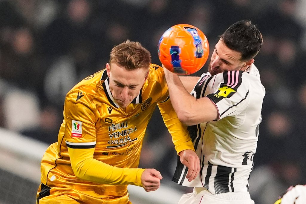 Juventus's Federico Gatti, right, and Udinese's Adam Buksa, left, challenge for the ball during the Italian soccer cup round of sixteen match between Juventus FC and Udinese in Turin, Italy , Dec. 2, 2025. (Fabio Ferrari/LaPresse via AP)