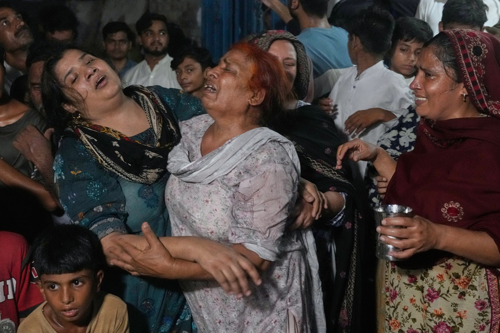 Women mourn over the death of their children killed after the roof of a tutoring center under-construction collapsed, on the outskirts of Lahore, Pakistan, Tuesday, June 30, 2026. (AP Photo/K.M Chaudary)