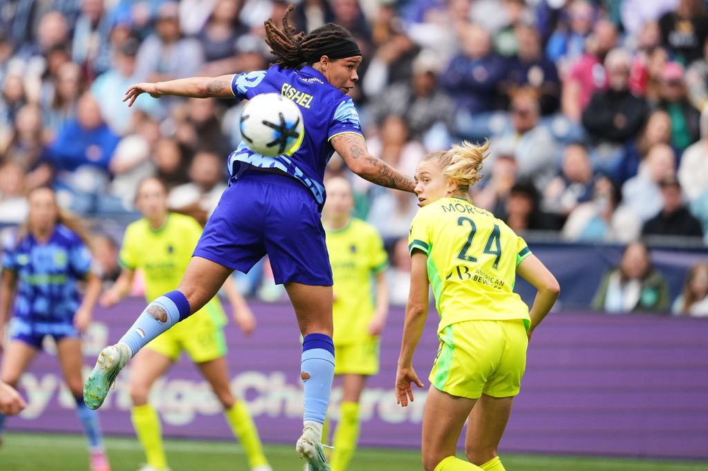 Seattle Reign FC forward Mia Fishel goes up for a header against Washington Spirit defender Esme Morgan (24) during the second half of an NWSL soccer match, Sunday, May 10, 2026, in Seattle. (AP Photo/Lindsey Wasson)