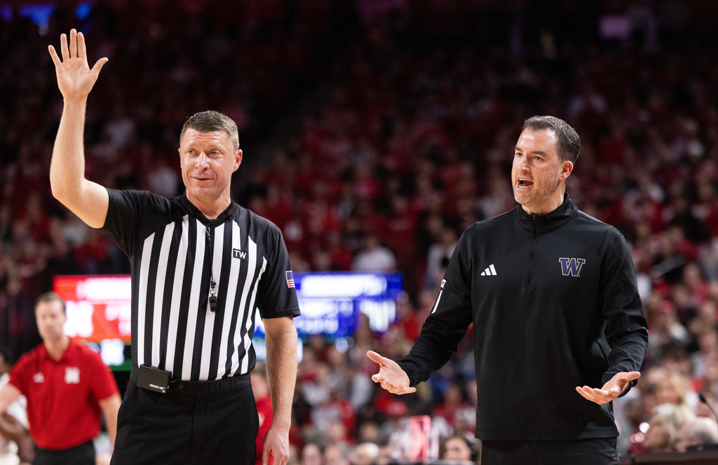 Washington head coach Danny Sprinkle, right, argues with a referee as his team plays against Nebraska during the first half of an NCAA college basketball game Wednesday, Jan. 21, 2026, in Lincoln, Neb. (AP Photo/Rebecca S. Gratz)