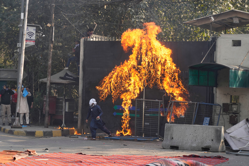 Shiite Muslims set a fire at the U.S. Consulate's entrance gate during a rally to condemn the killing of Iranian Supreme Leader Ayatollah Ali Khamenei, in Lahore, Pakistan, Sunday, March 1, 2026. (AP Photo/K.M. Chaudary)