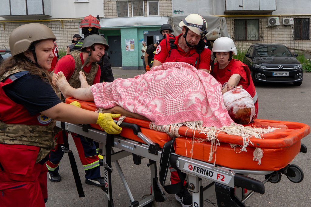 Rescuers evacuate an injured civilian after a residential building was hit following Russia's drone attack in Kharkiv, Ukraine, Sunday, Aug. 9, 2026. (AP Photo/Andrii Marienko)