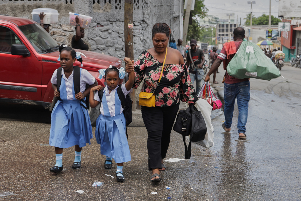Children cross a street after school in Port-au-Prince, Haiti, Wednesday, Oct. 1, 2025. (AP Photo/Patrice Noel)