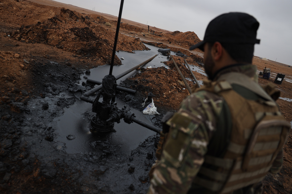 A Syrian government soldier walks at al-Thawra oil field after government troops took control of it from the U.S.-backed Syrian Democratic Forces (SDF) during an ongoing push against Kurdish-led forces, in Raqqa, northeastern Syria, Sunday, Jan. 18, 2026. (AP Photo/Omar Albam)