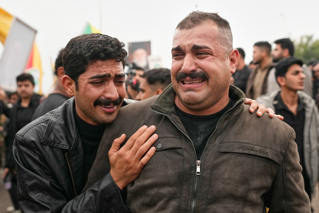 Relatives grieve in Baghdad, Iraq, Tuesday, March 24, 2026, during a funeral of members of the Popular Mobilization Forces who were killed in a U.S. airstrike in Anbar, Iraq. (AP Photo/Hadi Mizban)