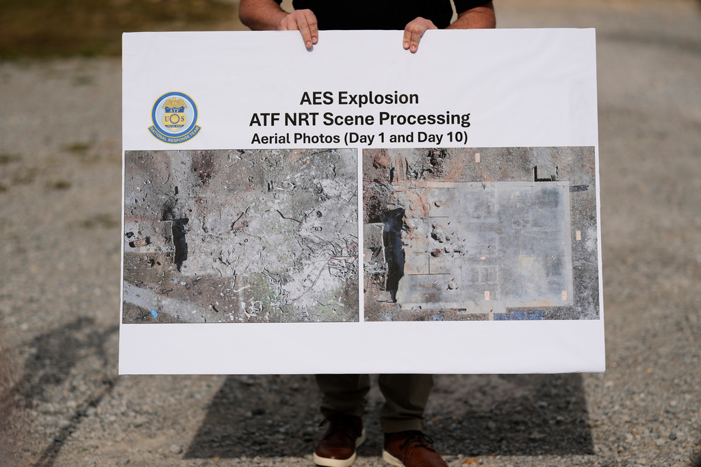 ATF agent Brice McCracken holds a photo of the blast site at Accurate Energetic Systems during a news conference Friday, Oct. 24, 2025, in McEwen, Tenn. (AP Photo/George Walker IV)