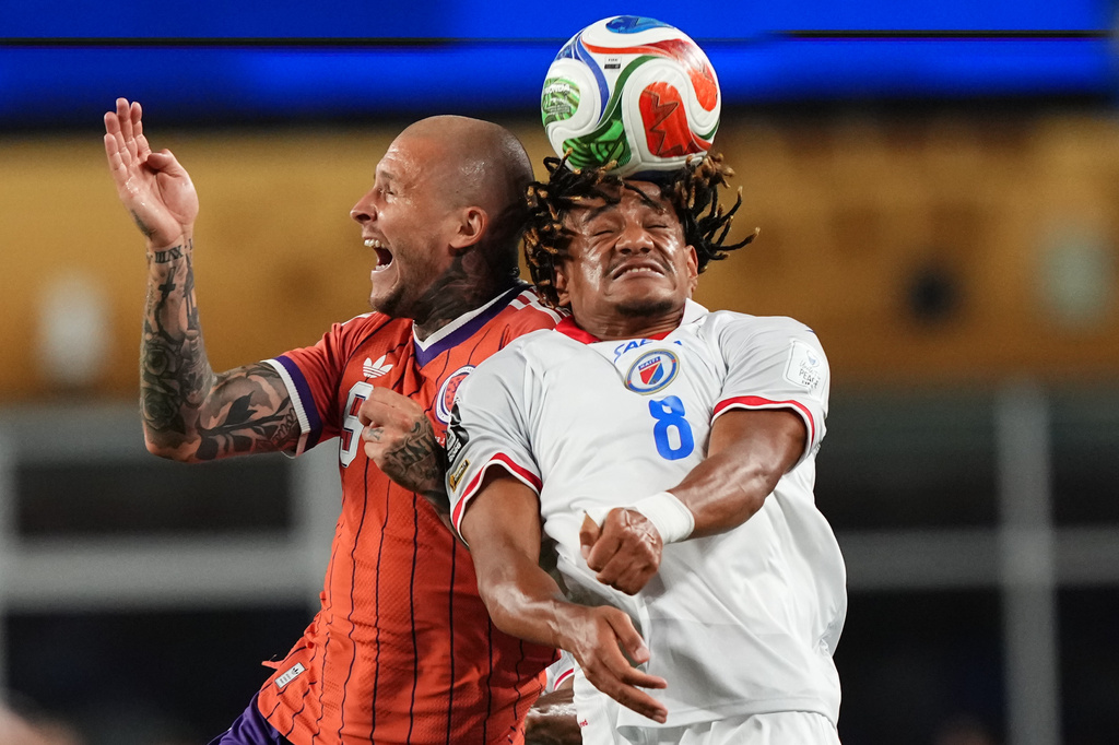 Scotland's Lyndon Dykes (9) and Haiti's Martin Experience (8) compete to head the ball during the World Cup Group C soccer match between Haiti and Scotland in Foxborough, Mass., near Boston, Saturday, June 13, 2026. (AP Photo/Martin Meissner)