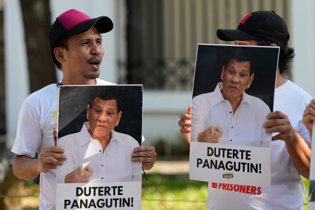 Activists hold pictures of former Philippine President Rodrigo Duterte during a rally before they watch a live stream of Duterte's pre-trial hearing from The Hague, at a venue in Quezon City, Philippines on Monday, Feb. 23, 2026. Sign reads "hold Duterte accountable".(AP Photo/Aaron Favila)