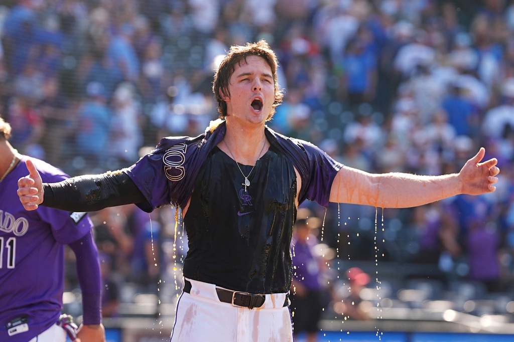 Colorado Rockies' Mickey Moniak yells after being doused by Orlando Arcia after hitting a walkoff RBI single off Chicago Cubs relief pitcher Daniel Palencia in the ninth inning of a baseball game Sunday, Aug. 31, 2025, in Denver. (AP Photo/David Zalubowski)