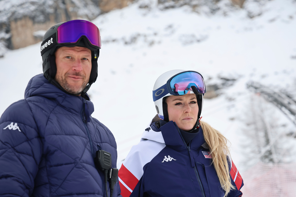 United States' Lindsey Vonn and coach Aksel Lund Svindal, left, ahead of an alpine ski, women's downhill official training, at the 2026 Winter Olympics, in Cortina d'Ampezzo, Italy, Friday, Feb. 6, 2026. (AP Photo/Marco Trovati)